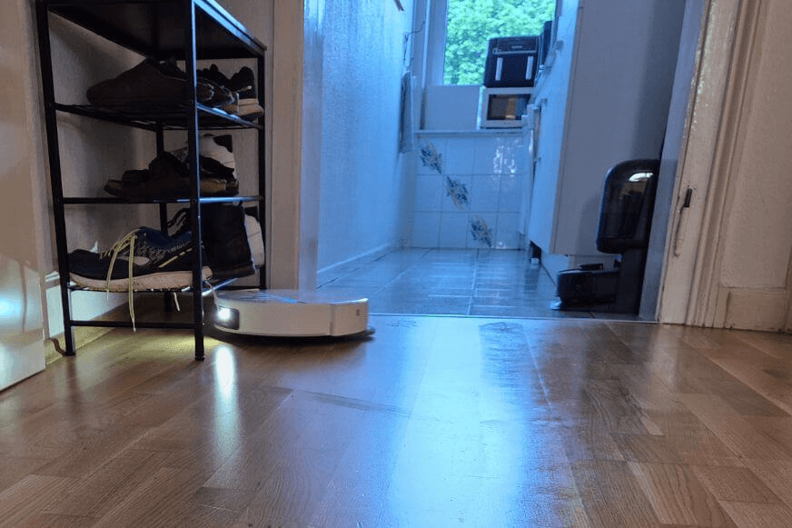 Dreame X60 vs MOVA V70 mit eingefahrenem Laserturm unter einem flachen Sofa